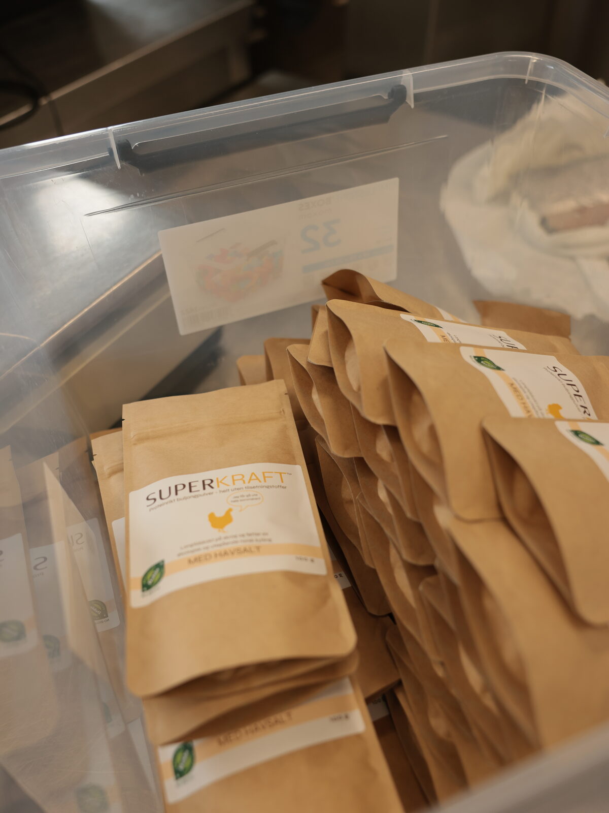En gjennomsiktig plastkasse full av forseglede poser Superkraft med havsalt