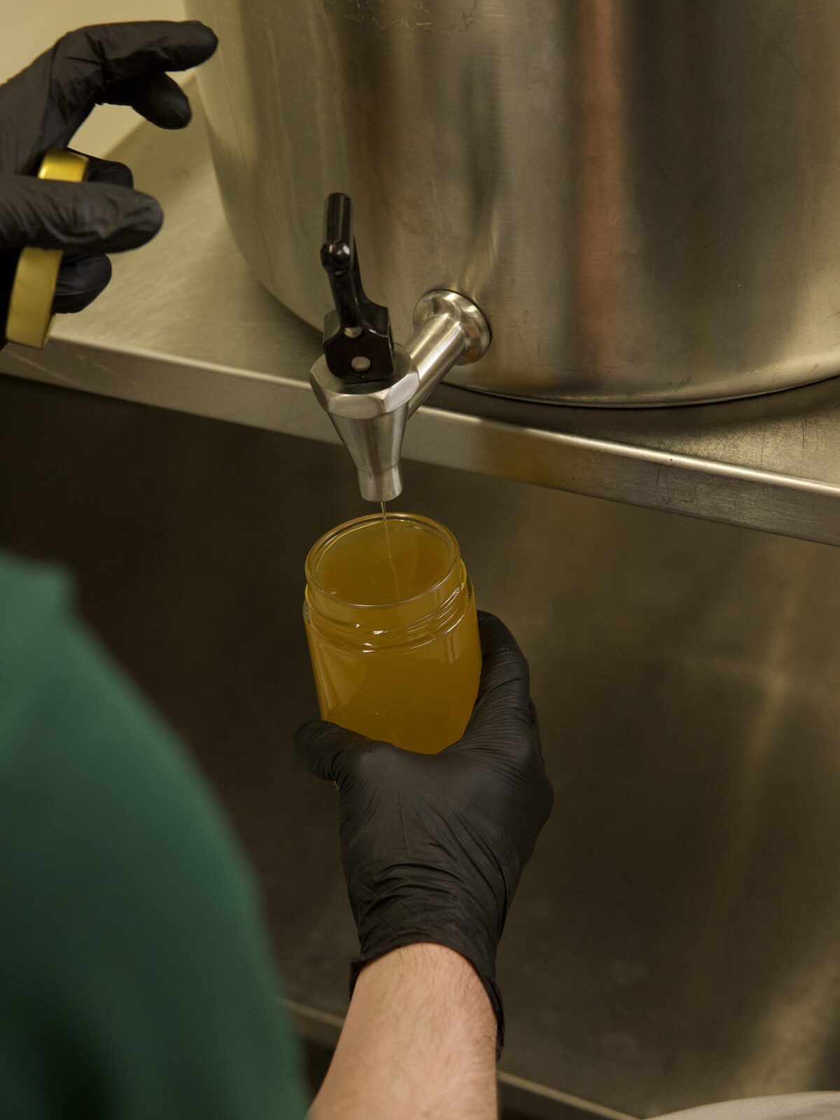 Et nesten fullt glass med gyllent fett under kranen