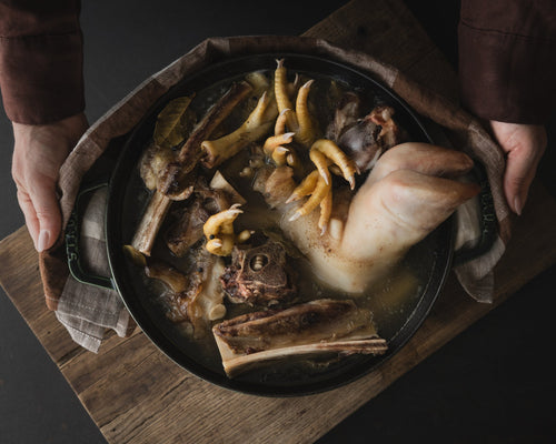 Hender holder en jerngryte med kraftbein, fra boka KRAFT