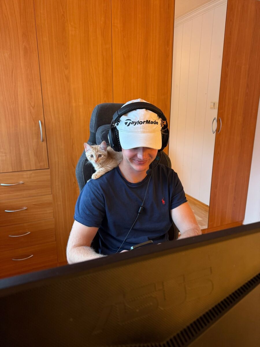 Leonard ved PC-en med katten Lasse på skulderen